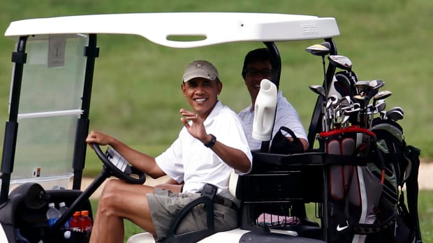 US President Obama waves from a golf ca