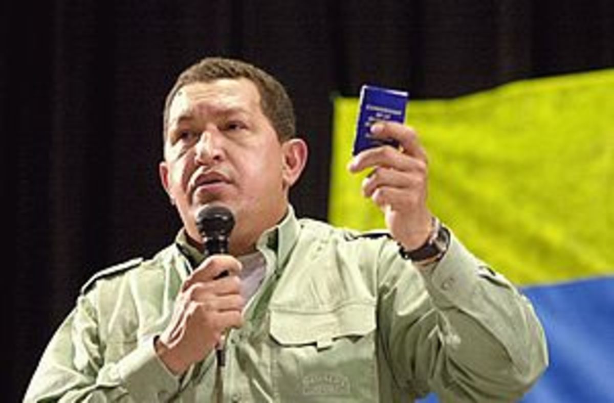 Chávez holds a miniature copy of the 1999 Vene...