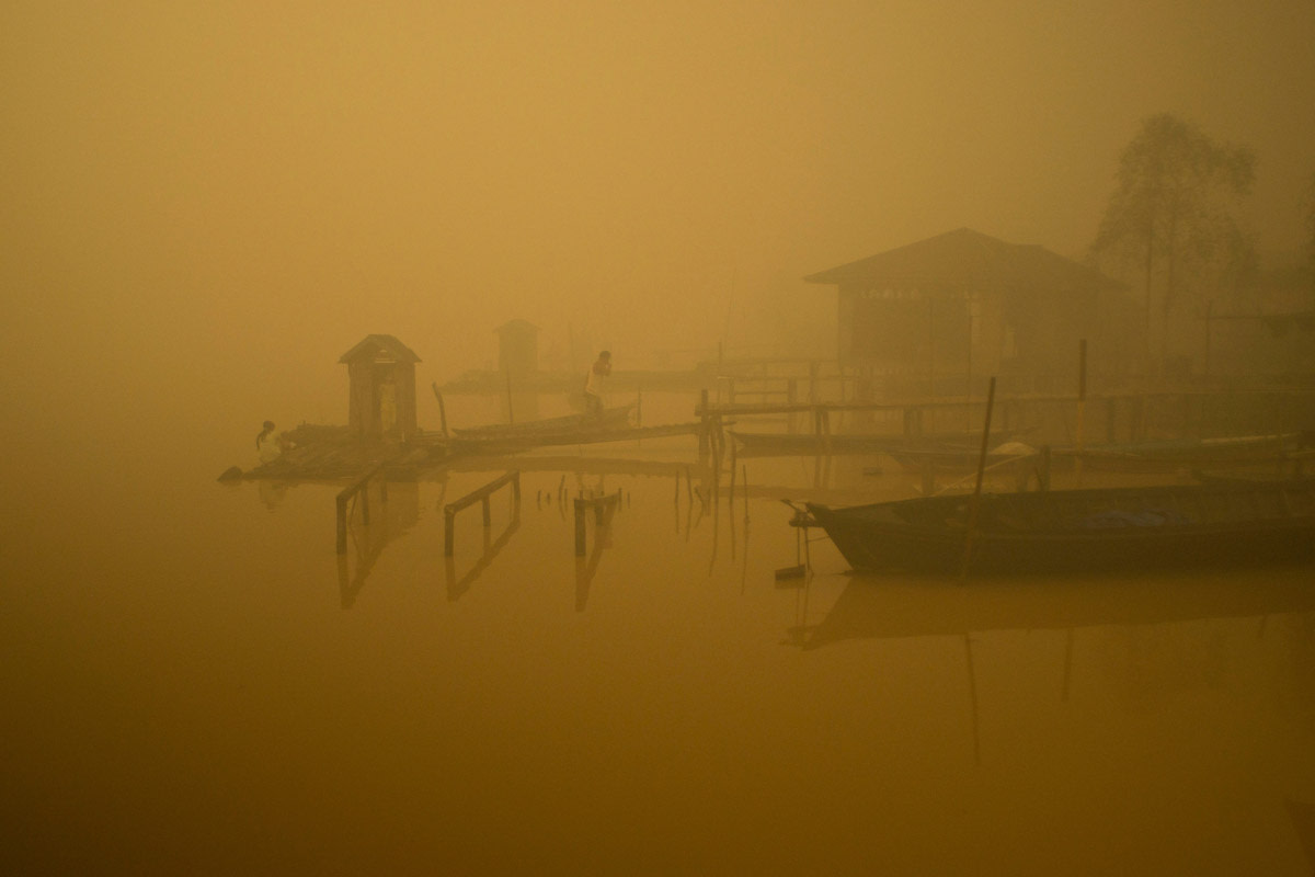 Members of the indigenous community live at the riverbanks in Kapuas river where the air is engulfed with thick haze at Sei Ahass village, Kapuas district, Central Kalimantan province on Borneo island, Indonesia. These fires are a threat to the health of millions. Smoke from landscape fires kills an estimated 110,000 people every year across Southeast Asia, mostly as a result of heart and lung problems, and weakening newborn babies.